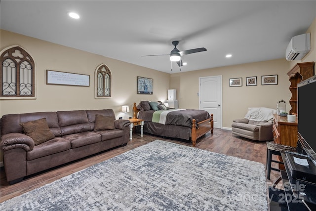 bedroom with hardwood / wood-style flooring, ceiling fan, and a wall mounted AC