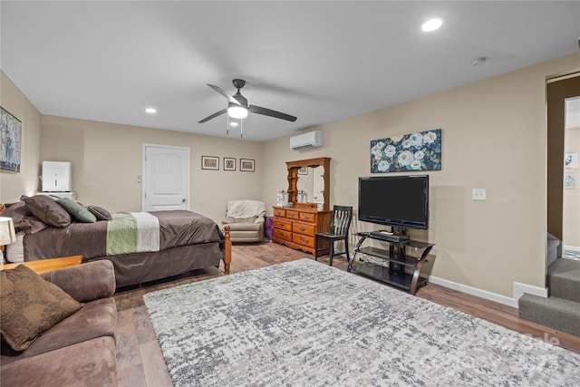 bedroom featuring ceiling fan, hardwood / wood-style flooring, and a wall mounted AC