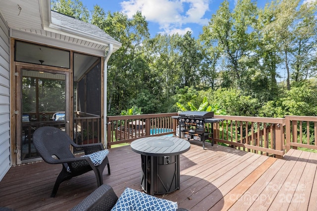 wooden terrace with area for grilling and a sunroom