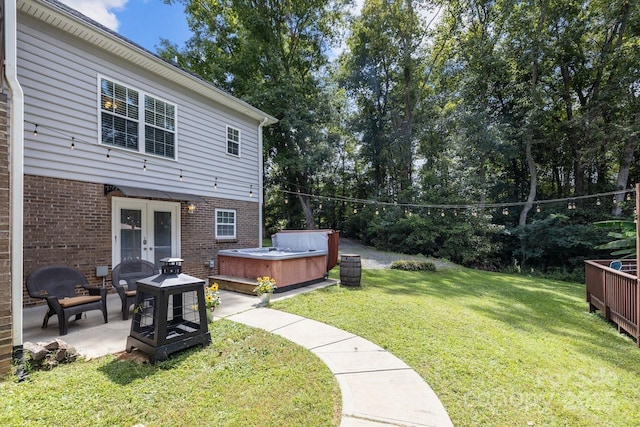 view of yard featuring a patio, a hot tub, and french doors