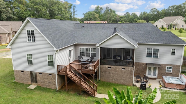 rear view of house featuring a patio area, a hot tub, a lawn, a deck, and a sunroom