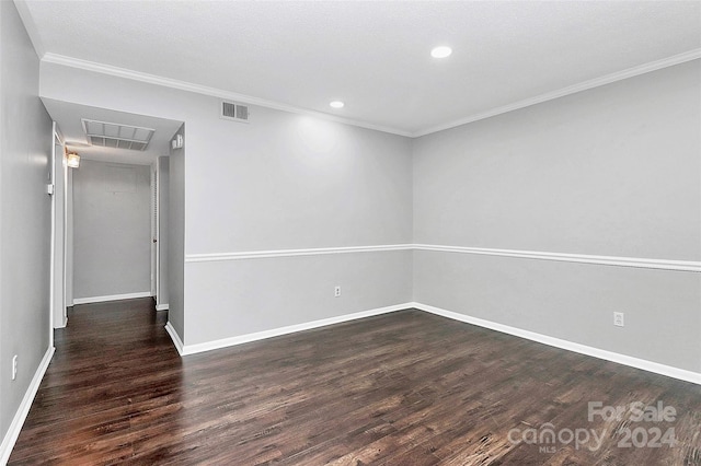 empty room featuring dark hardwood / wood-style flooring and crown molding