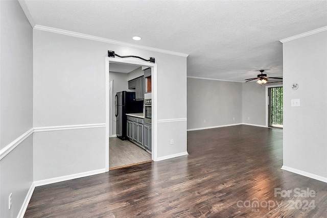 spare room featuring ceiling fan, dark hardwood / wood-style floors, ornamental molding, and a textured ceiling