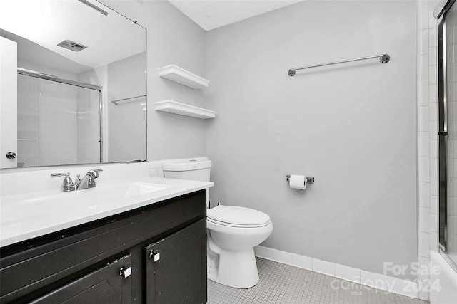 bathroom featuring a shower with door, vanity, toilet, and tile patterned flooring