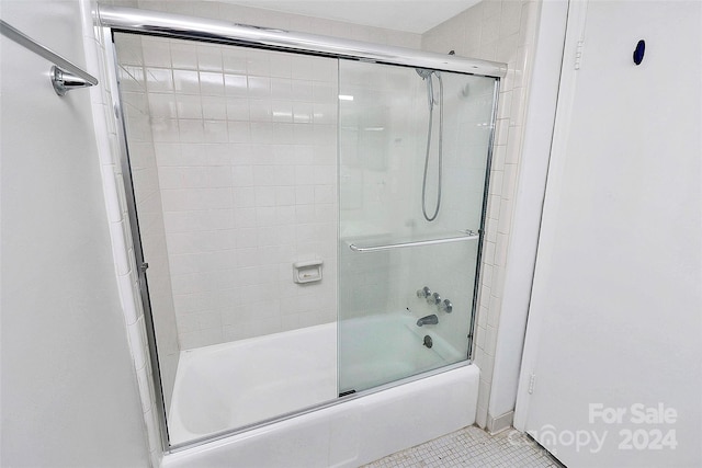 bathroom with tile patterned flooring and combined bath / shower with glass door