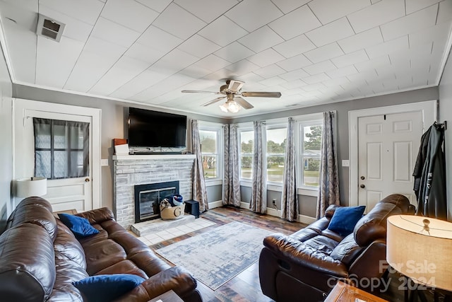 living room featuring ceiling fan, ornamental molding, hardwood / wood-style flooring, and a fireplace