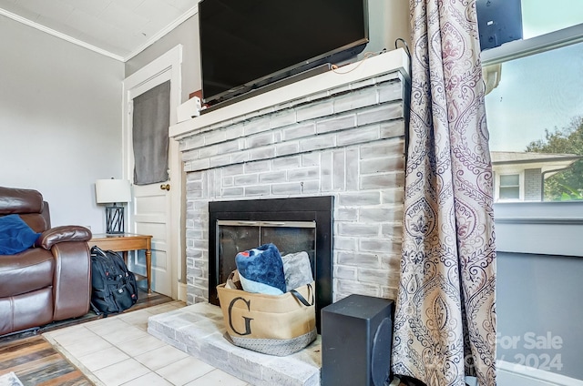 interior space featuring a fireplace, ornamental molding, and hardwood / wood-style floors