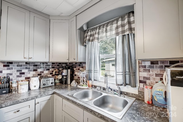 kitchen with gray cabinets, tasteful backsplash, and sink