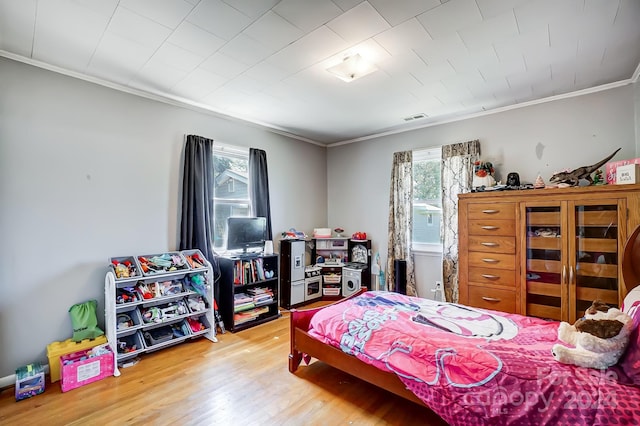 bedroom with light wood-type flooring and crown molding