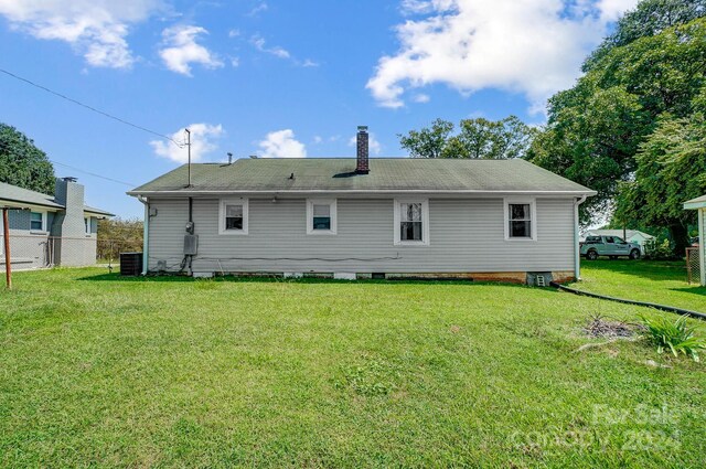 rear view of house with a lawn and central air condition unit