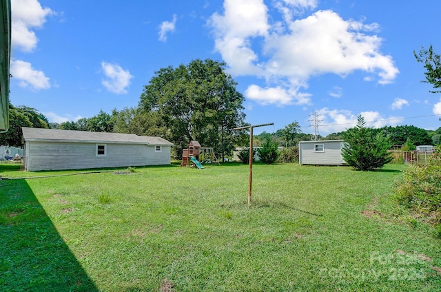 view of yard featuring a playground and a shed