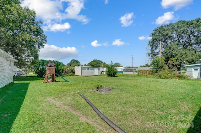 view of yard with a playground and a storage unit