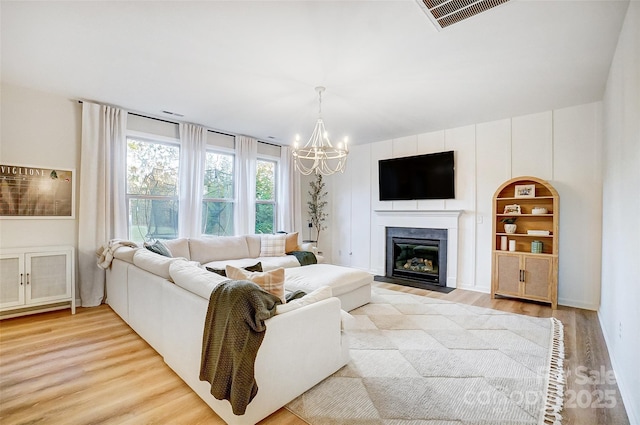 living room featuring light wood-type flooring and an inviting chandelier