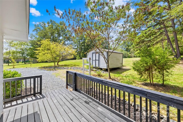 wooden deck with a storage shed and a yard