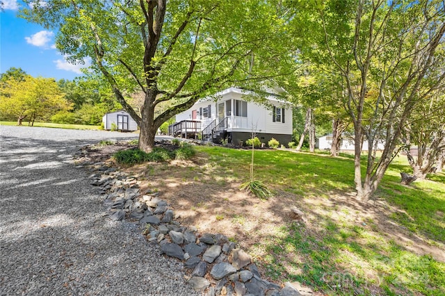 view of front of home featuring a front yard and a shed