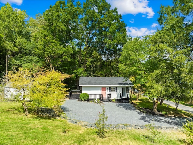 view of front facade featuring a front yard and a wooden deck