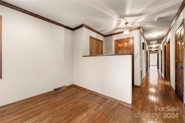 unfurnished room featuring crown molding and dark wood-type flooring