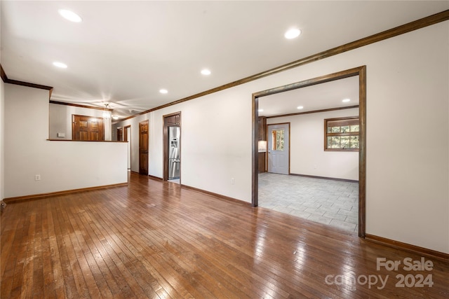 spare room with wood-type flooring and crown molding