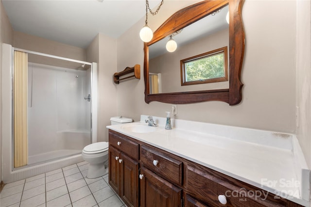 bathroom featuring tile patterned flooring, vanity, toilet, and walk in shower