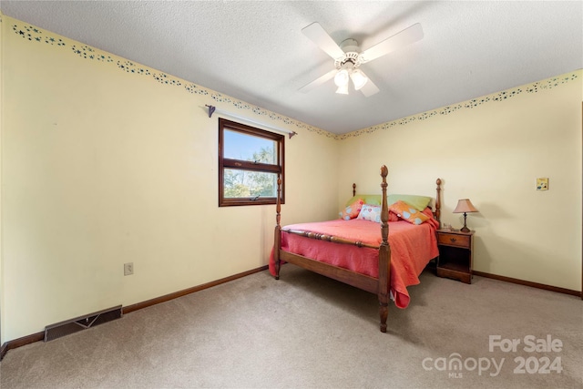 bedroom with carpet, ceiling fan, and a textured ceiling