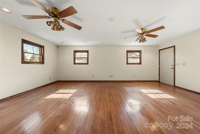 spare room with ceiling fan, a healthy amount of sunlight, and light wood-type flooring