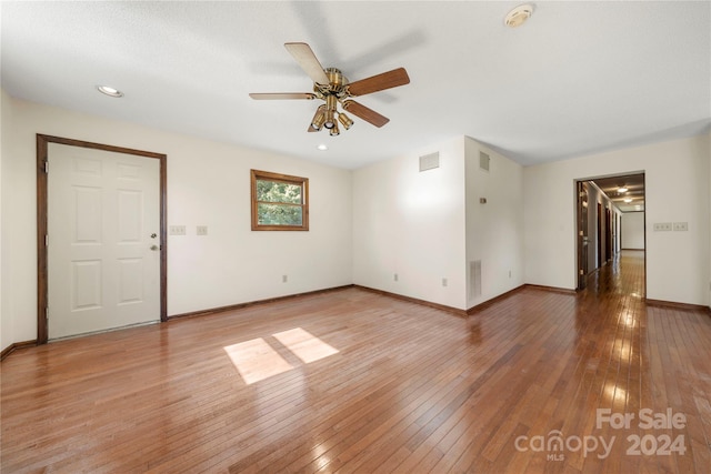 empty room with hardwood / wood-style flooring and ceiling fan