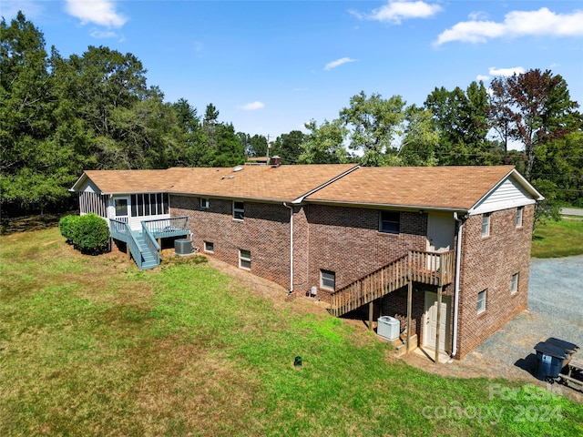 rear view of property with cooling unit, a yard, and a wooden deck