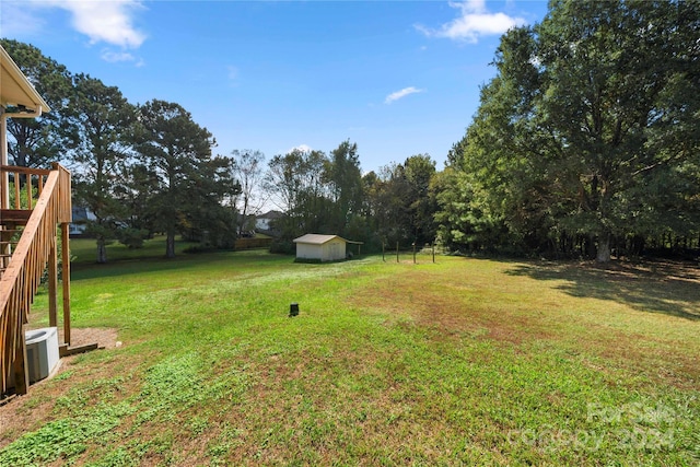 view of yard featuring a storage shed and central AC