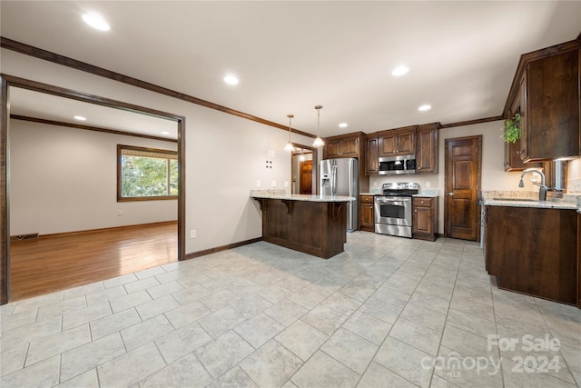 kitchen featuring a kitchen breakfast bar, hanging light fixtures, appliances with stainless steel finishes, light hardwood / wood-style floors, and kitchen peninsula