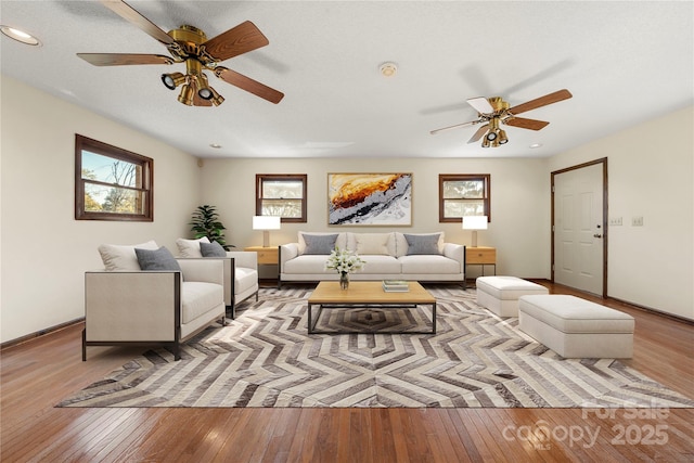 living room featuring light wood-style floors, recessed lighting, ceiling fan, and baseboards