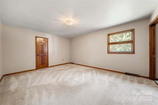 unfurnished room featuring baseboards, visible vents, and light colored carpet