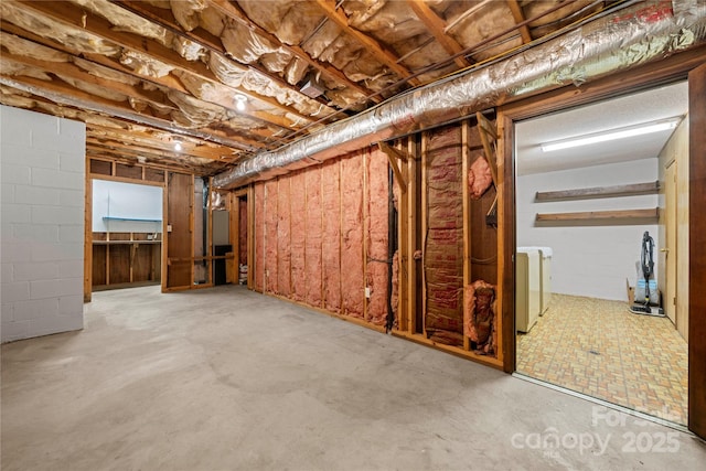 unfinished below grade area featuring washing machine and dryer and concrete block wall