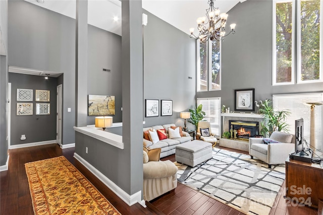 living room with a wealth of natural light, high vaulted ceiling, and a fireplace