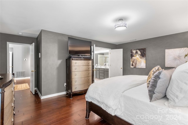 bedroom with connected bathroom and dark hardwood / wood-style floors