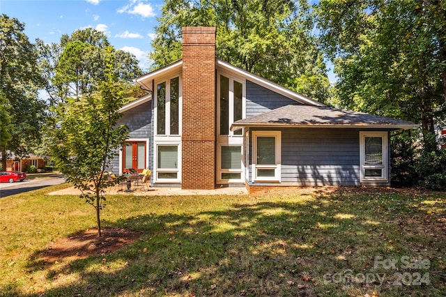 rear view of property with a yard