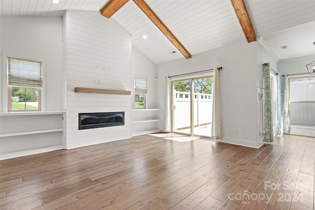 unfurnished living room with high vaulted ceiling, a fireplace, hardwood / wood-style flooring, and beam ceiling