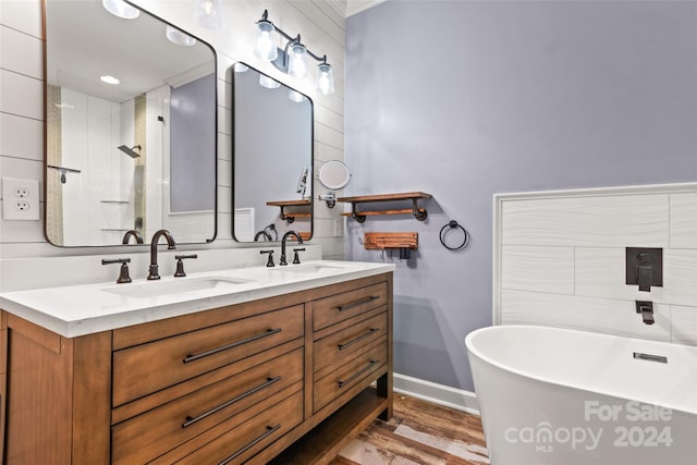 bathroom with independent shower and bath, wood-type flooring, and vanity