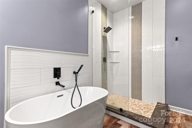 bathroom with shower with separate bathtub and hardwood / wood-style flooring