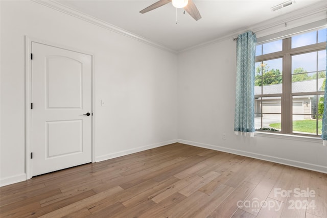 spare room with light wood-type flooring, ceiling fan, and crown molding