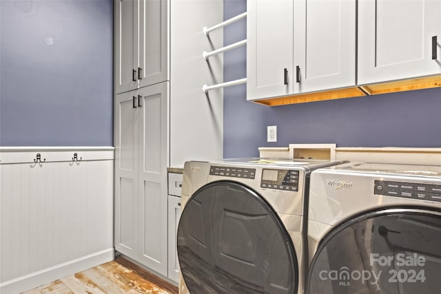 laundry room featuring cabinets, independent washer and dryer, and light hardwood / wood-style floors