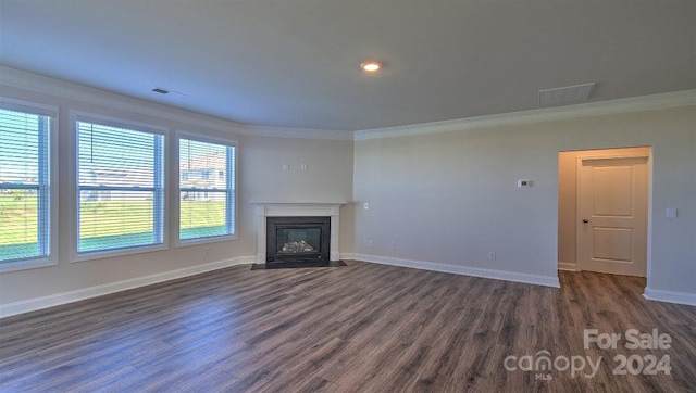 unfurnished living room with a fireplace, ornamental molding, and dark hardwood / wood-style floors