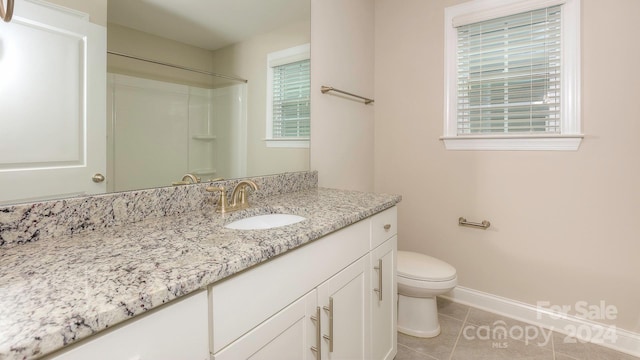 bathroom featuring plenty of natural light, vanity, toilet, and tile patterned flooring