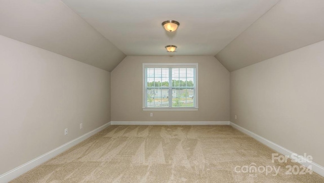 bonus room featuring light carpet and vaulted ceiling