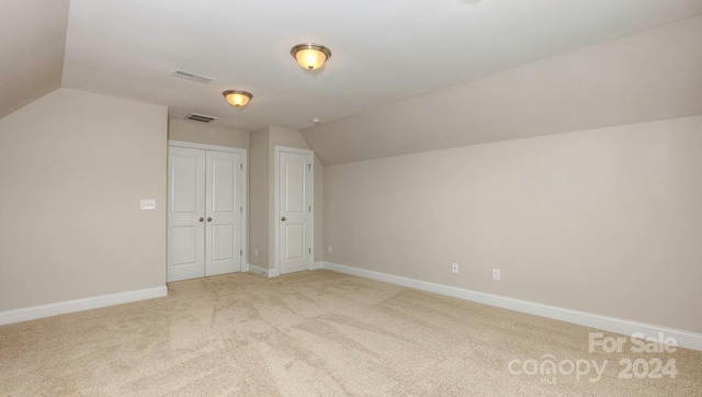 additional living space with lofted ceiling and light carpet