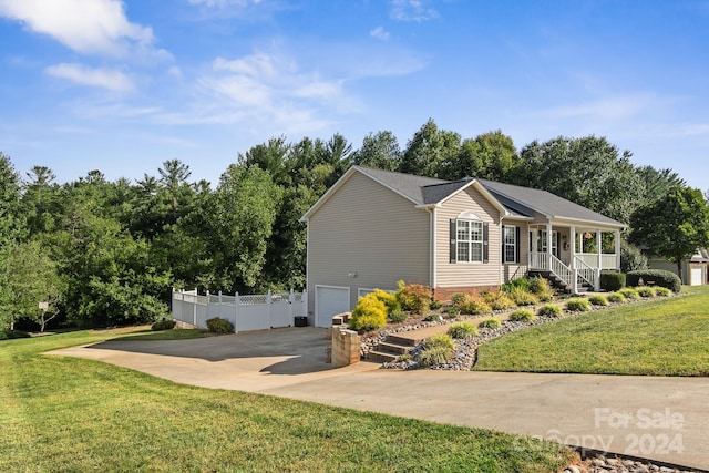 ranch-style home featuring a garage, a porch, and a front yard