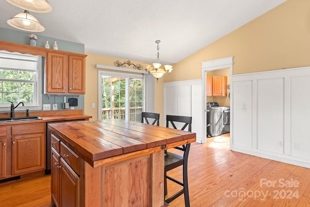 kitchen with stainless steel range, light hardwood / wood-style flooring, wooden counters, a center island, and sink