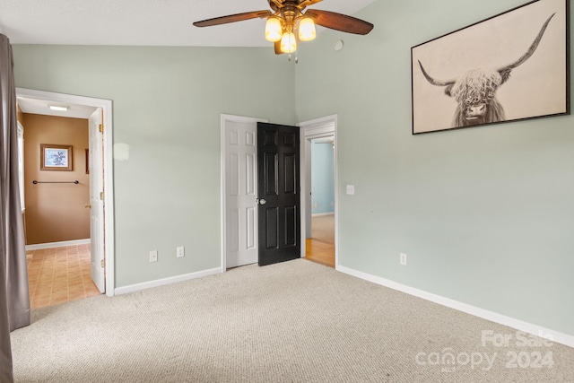 unfurnished bedroom with lofted ceiling, ceiling fan, and carpet floors