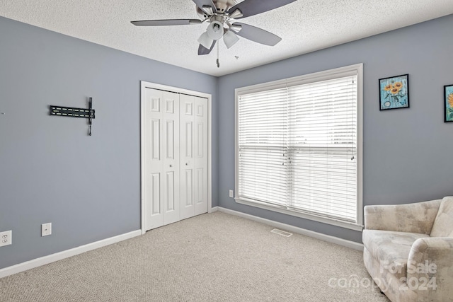 sitting room featuring light carpet, a wealth of natural light, and ceiling fan