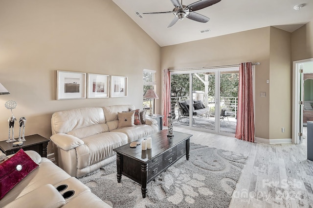 living room featuring high vaulted ceiling, ceiling fan, and light wood-type flooring