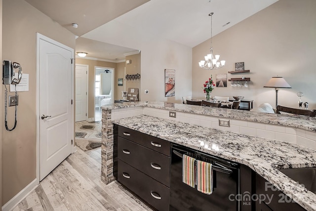 kitchen featuring light stone counters, decorative light fixtures, light wood-type flooring, and an inviting chandelier